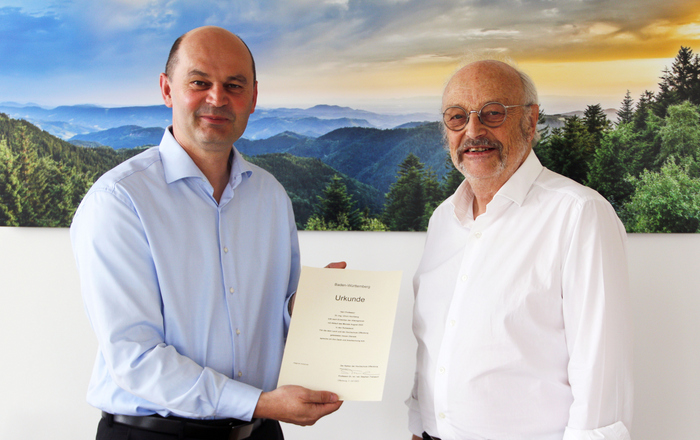 Rektor Prof. Dr. Stephan Trahasch (links) und Prof. Dr. Ulrich Hochberg (rechts) vor einem Schwarzwaldfoto